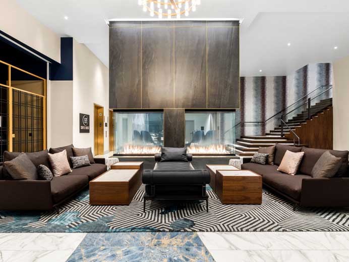 Hotel Indigo lobby with two-story stone fireplace and grand stair, Vancouver waterfront