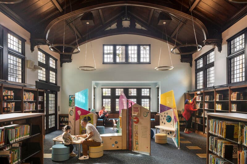 Midland Library renovated interior with restored barrel-vaulted dark-wood ceiling, tall arched windows, and chandeliers, Portland, Oregon
